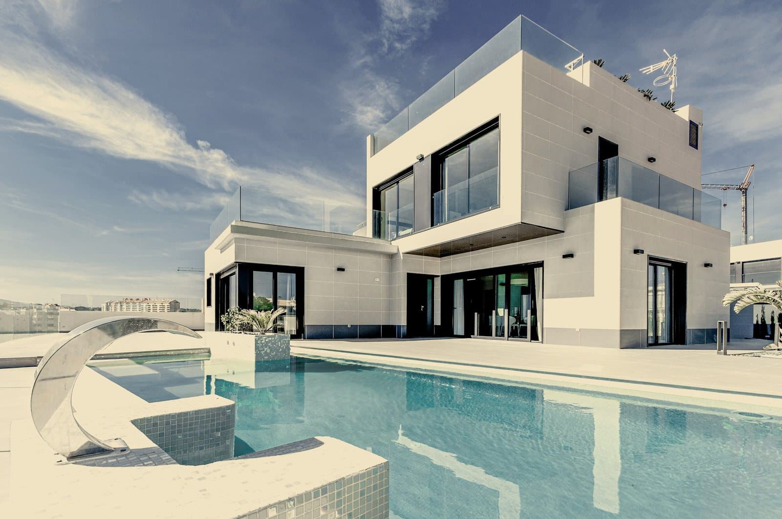 A modern white villa beside its pool