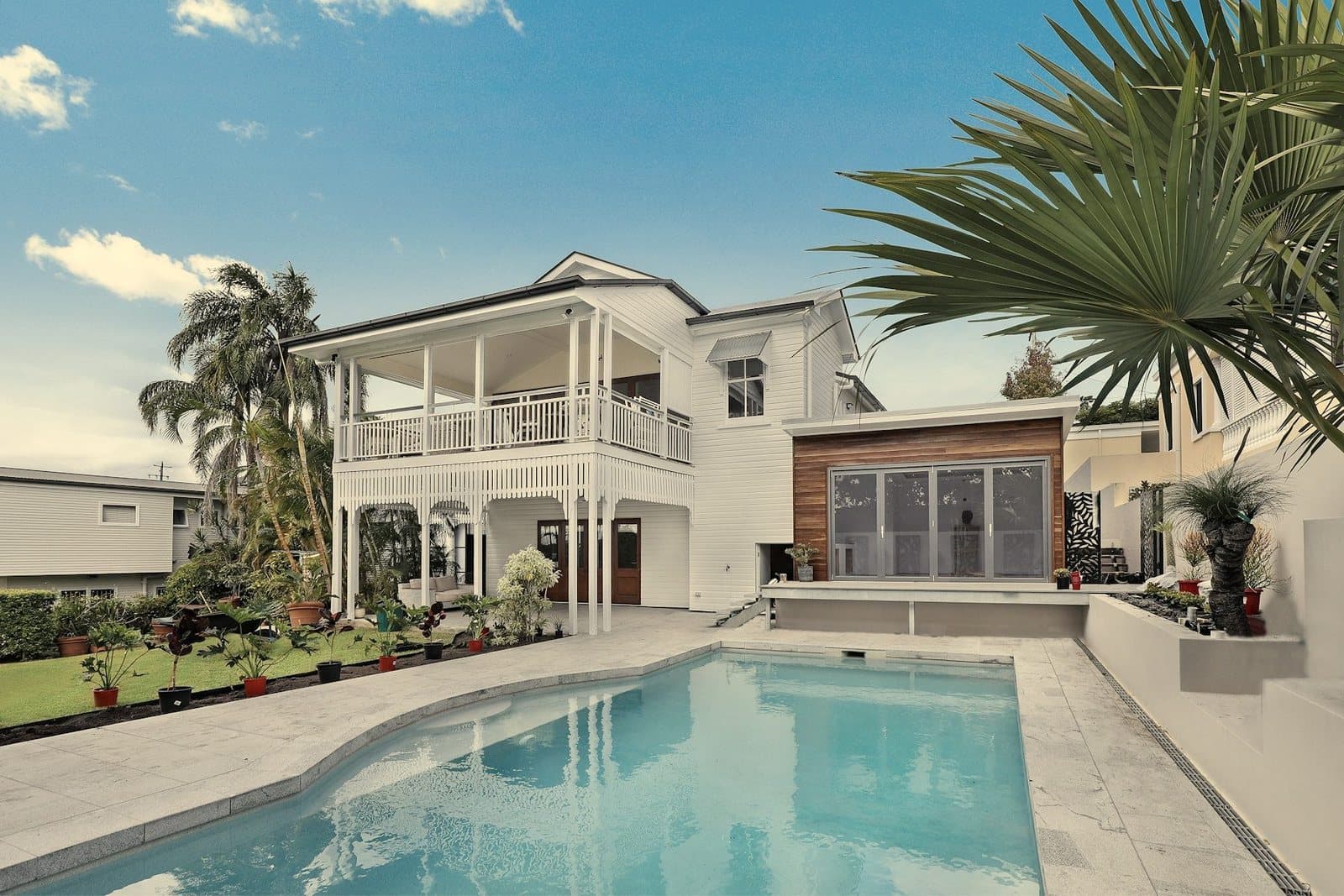 A white Florida pool home under palm trees